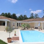 Maison avec imitation de pierres légèrement colorées devant pisicne