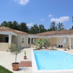 Maison avec imitation de pierres légèrement colorées devant pisicne