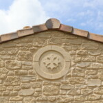 Oeil de boeuf décoratif avec croix occitane