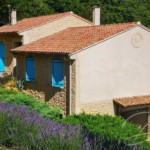 Maison avec façade ravalée grâce à un enduit imitation pierre et torchis vieilli